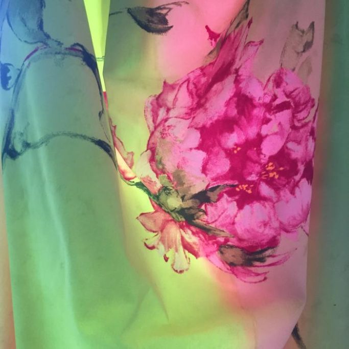 Wir lieben STOFFE Bunte Blütenmuster auf einem transparenten Stoff mit sanften Lichtreflexen.