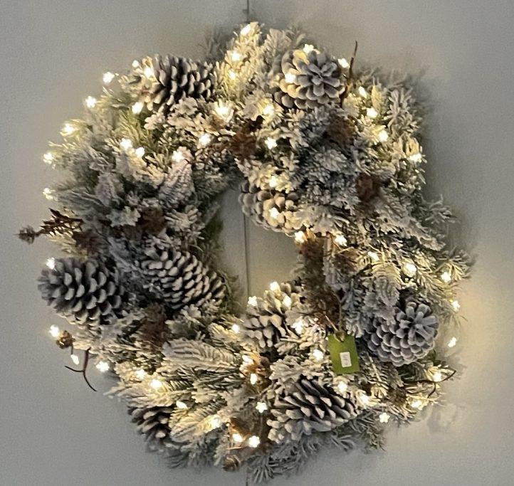 "Pop-up-Store" 2026 im Jugendstil-Hof Frostiger Kranz mit Tannenzapfen und Lichtern, dekorativ für die Winterzeit.