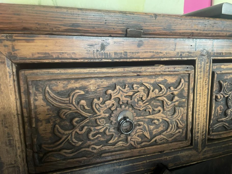 Antikes Meisterstück aus der Qing-Dynastie Detail eines kunstvoll geschnitzten Holzschranks mit floralen Mustern.